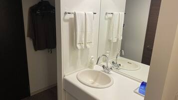 Un baño con dos lavamanos, un espejo y un perchero para toallas.