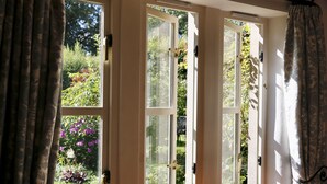 A room with three open French doors leading to a garden. - Ashfield House (Skipton)