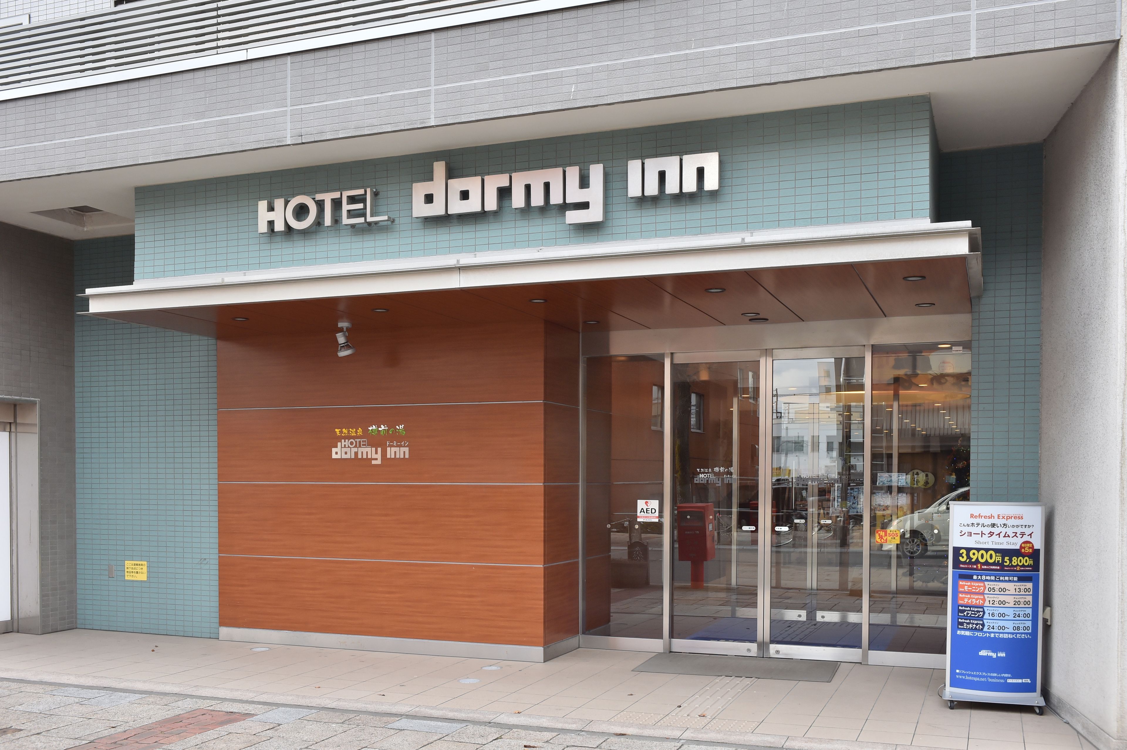 Entrada de un hotel con un letrero que dice "HOTEL dormy inn".