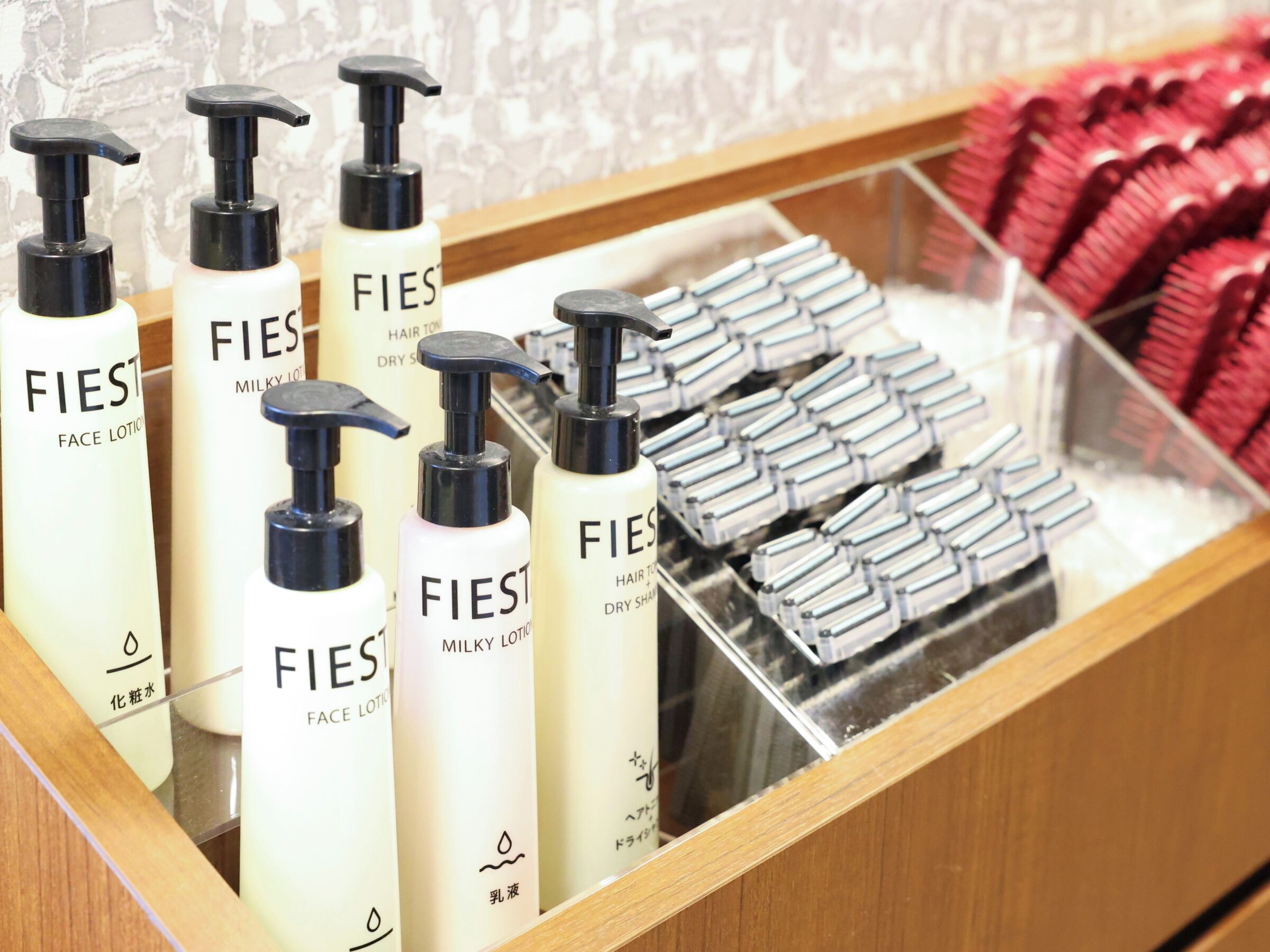 A display of FIES face lotion bottles and hair care products in a store.