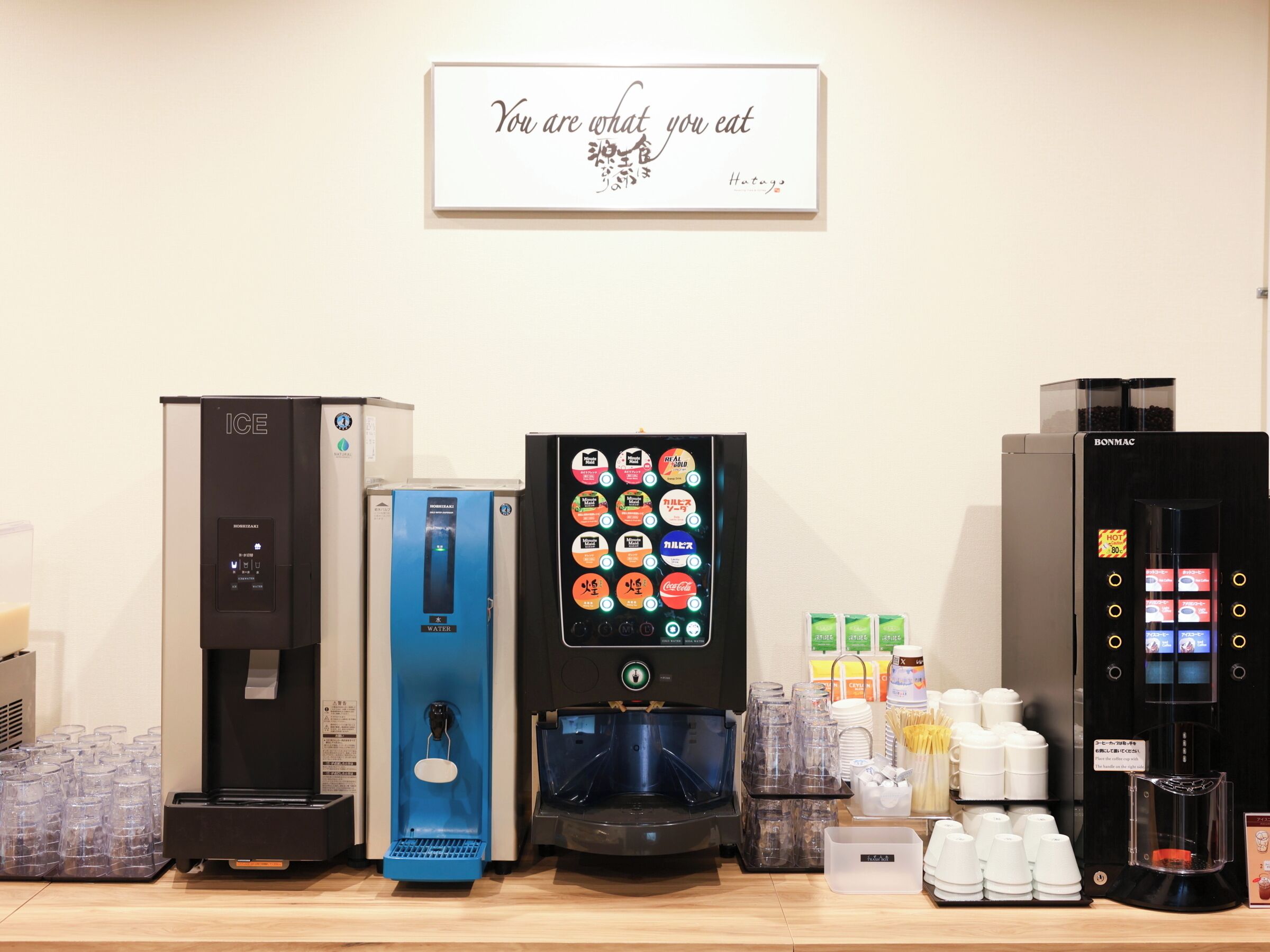 A beverage station with various drink dispensers, including a water cooler, a coffee machine, and a hot drink dispenser.