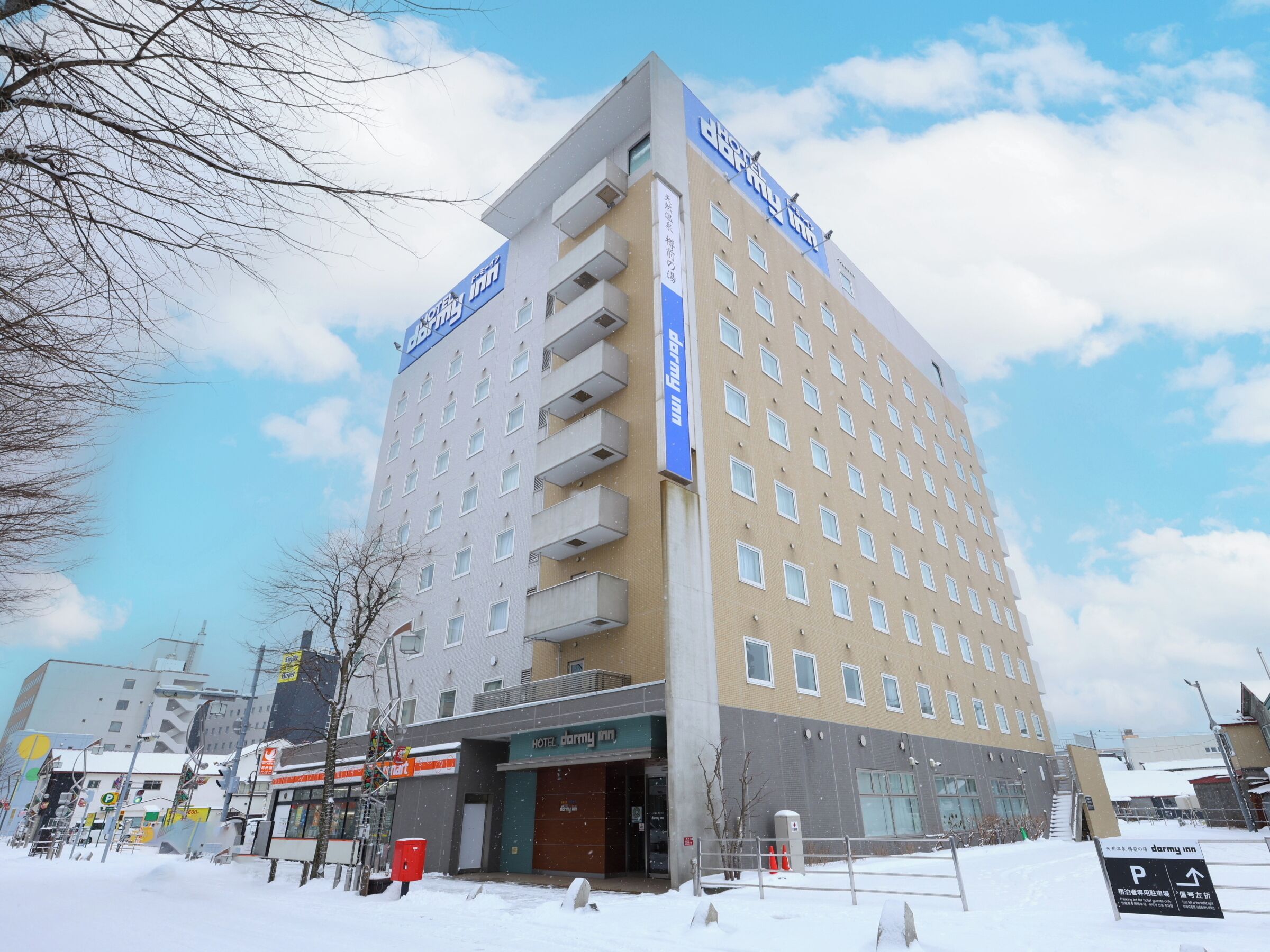 A multi-story hotel with a prominent sign, a ground-level entrance, and a parking area.
