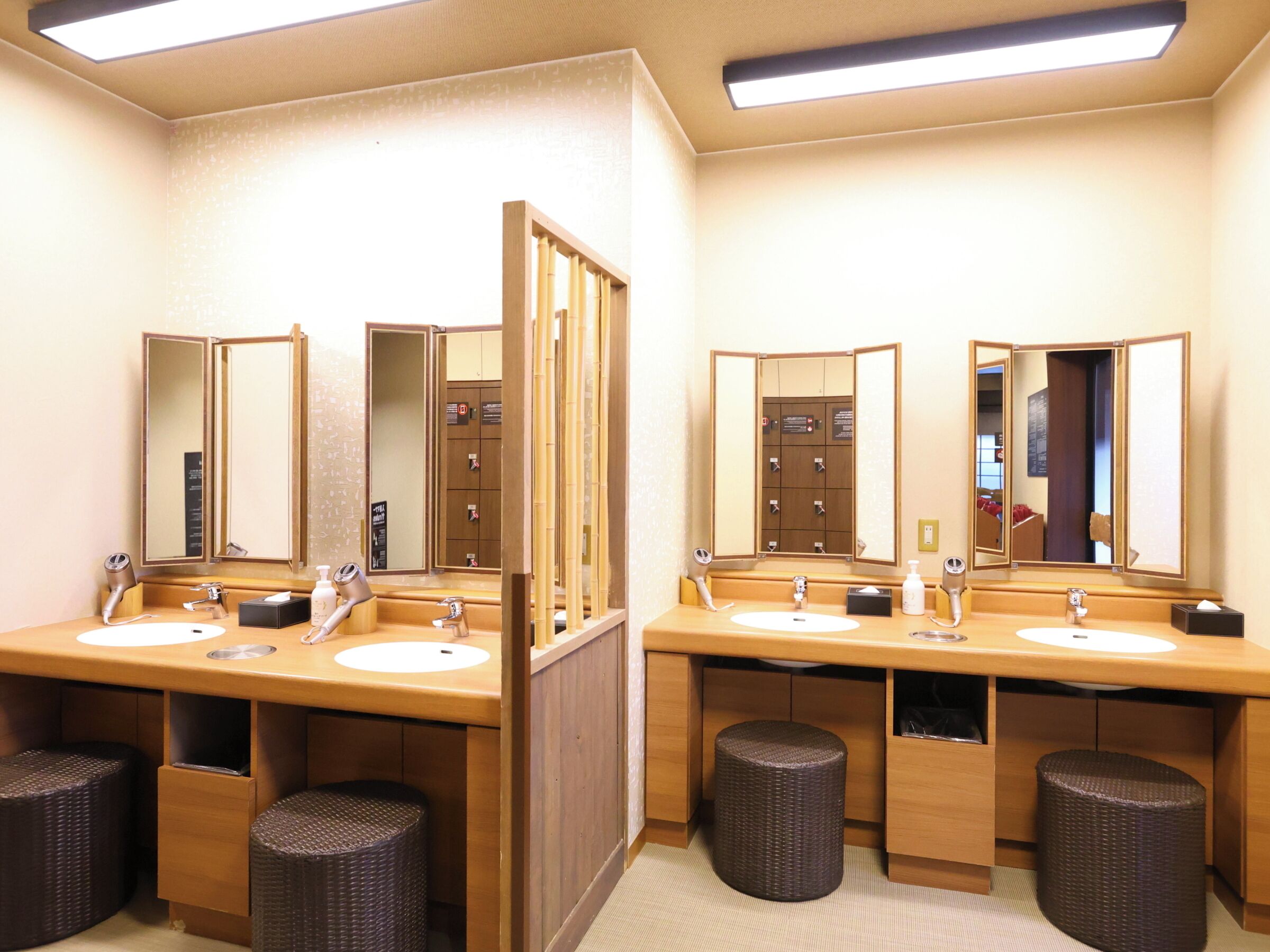 A hotel bathroom with two sinks, mirrors, and a towel rack.