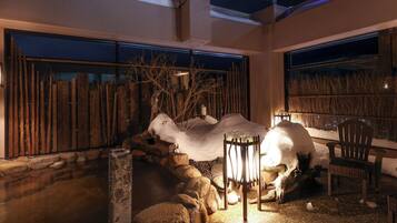 A snow-covered outdoor seating area with stone walls and wooden fences.