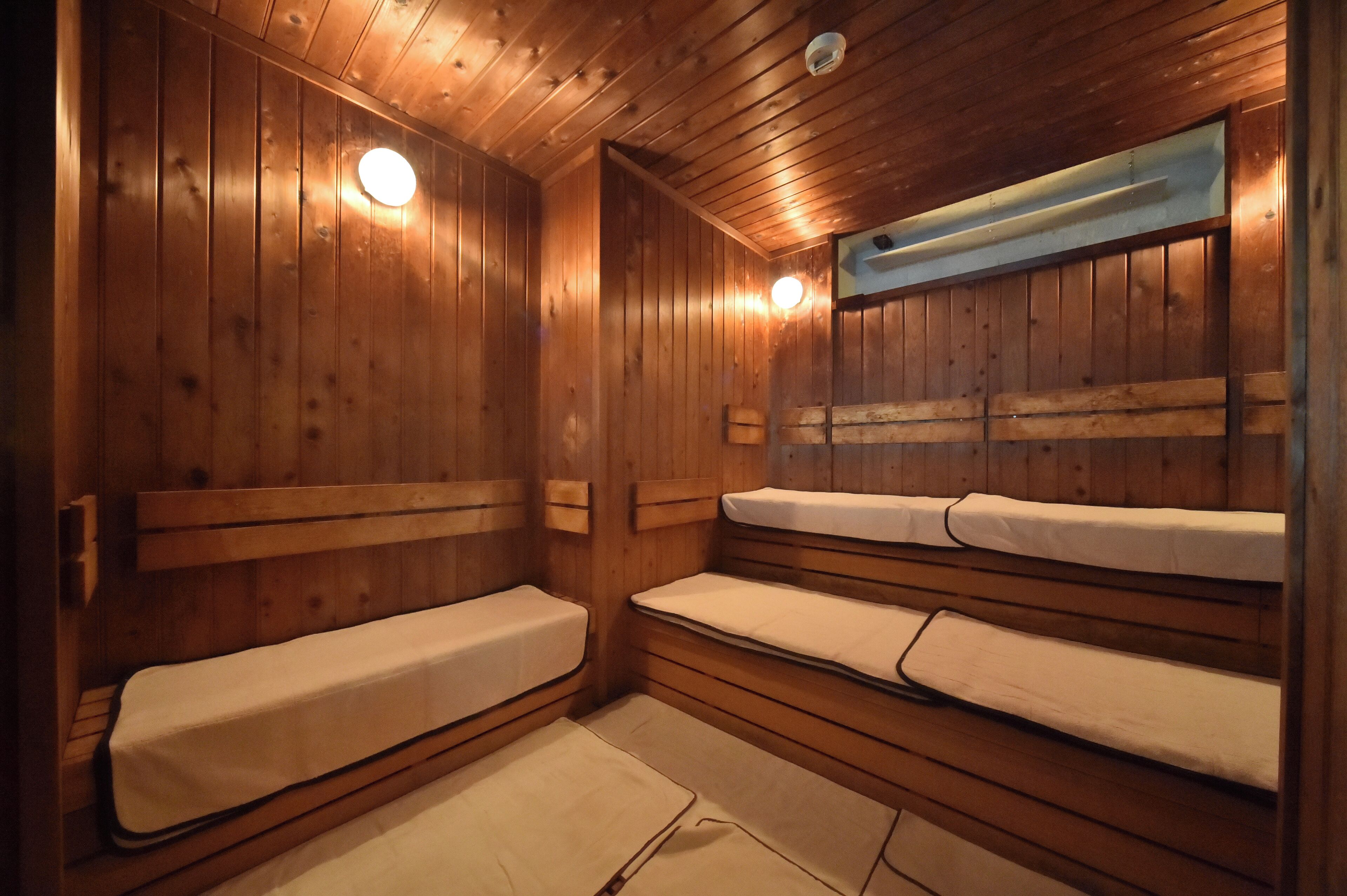 A wooden cabin with bunk beds, a wooden ceiling, and a small window.