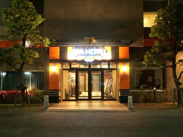 A hotel entrance with a sign reading "APA HOTEL" and a visible entrance door.