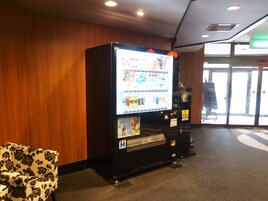 A vending machine with a digital display, a wheelchair-accessible area, and a door with a sign.