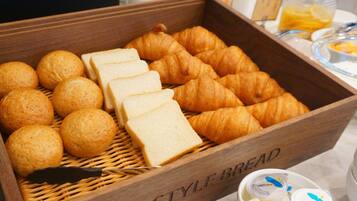 Una caja de madera con la etiqueta 'STYLE BREAD' que contiene panes y pasteles variados.