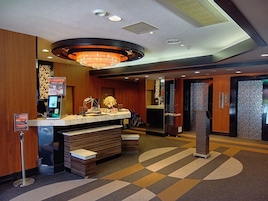A hotel reception area with a marble counter, a chandelier, and a wheelchair-accessible entrance.