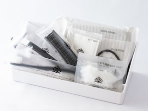 A white box containing a hairbrush, cotton towel, hair ring, and a hair cap.