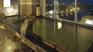A hot tub with a city view at night. - Natural Hot Spring Dormy Inn Premium Kushiro (Kushiro)