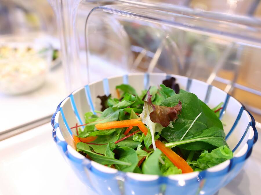 Un tazón de ensalada con diferentes verduras y zanahorias.