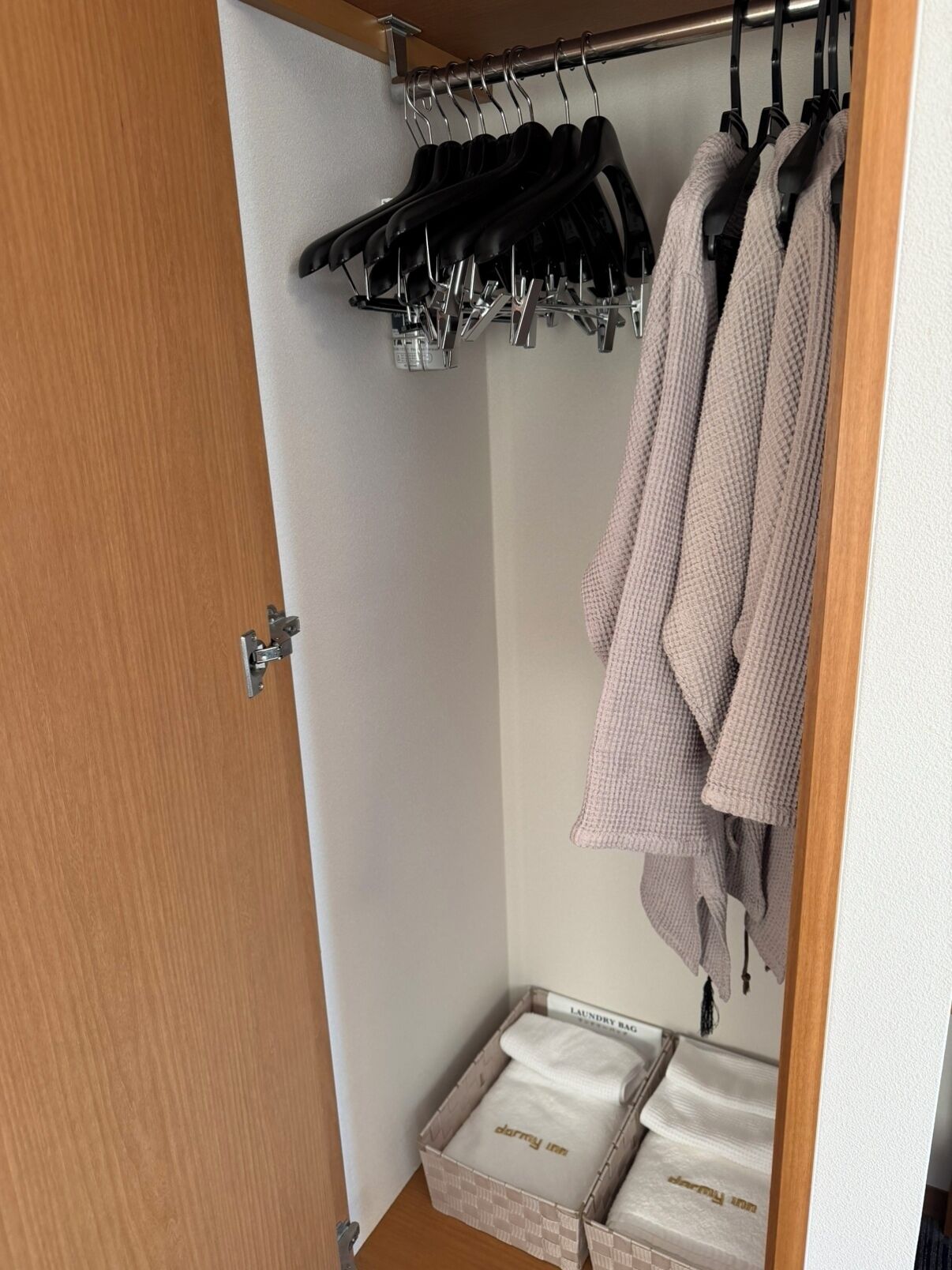 Un armario con ropa colgada y cajas de almacenamiento etiquetadas 'darryy inn'.