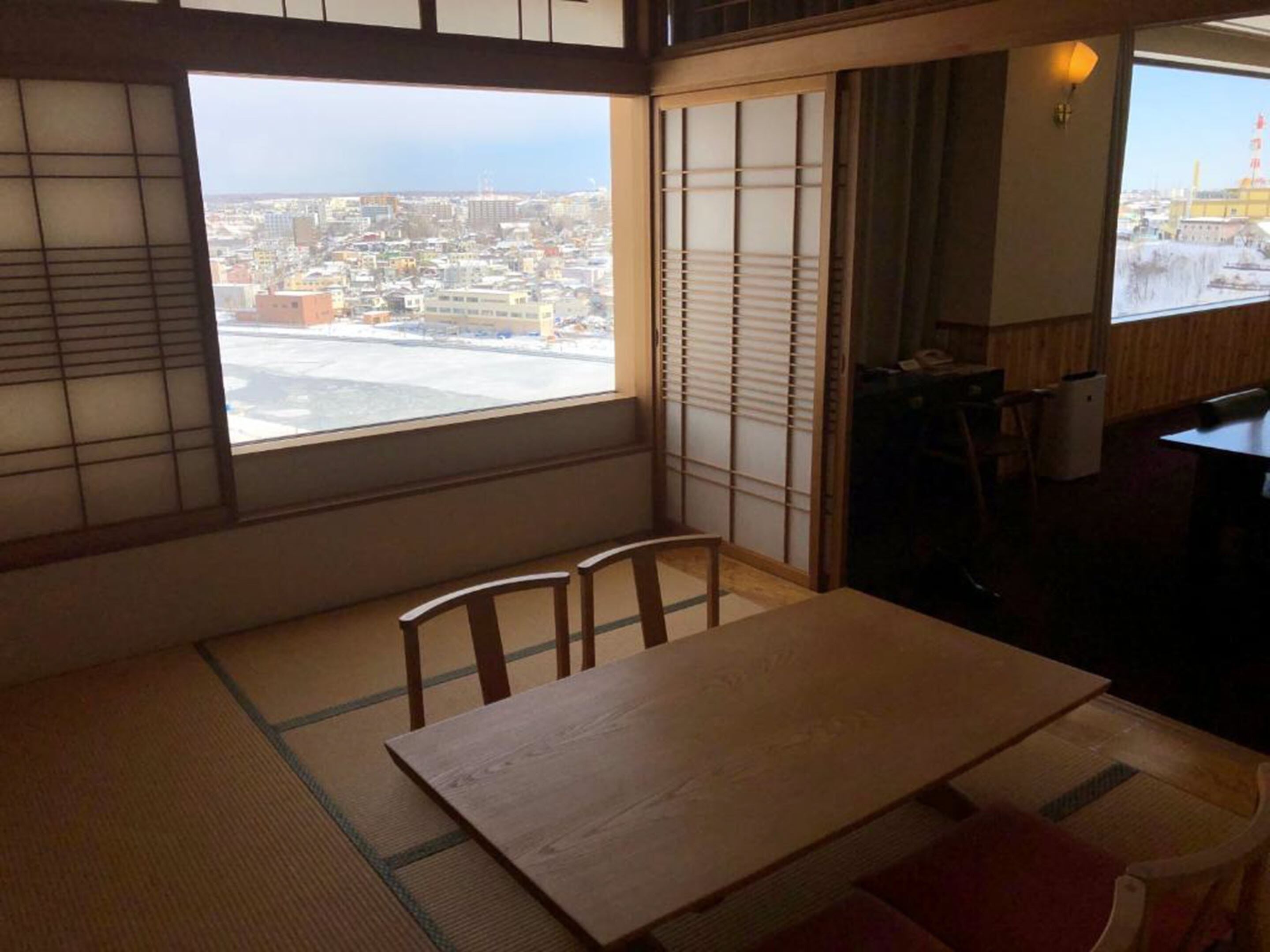 A traditional Japanese room with tatami flooring, a low wooden table, and sliding shoji doors.