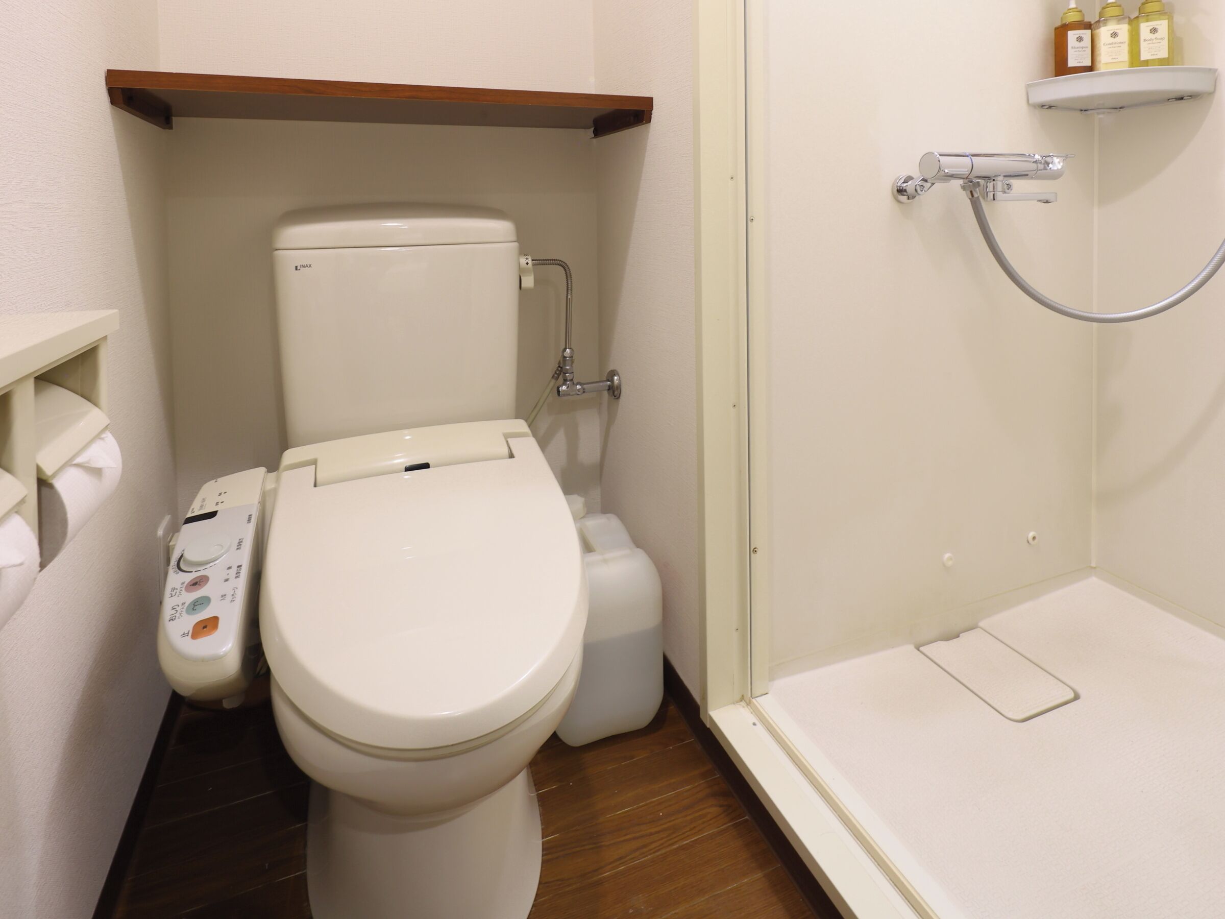 A modern bathroom with a toilet, bidet, and shower.