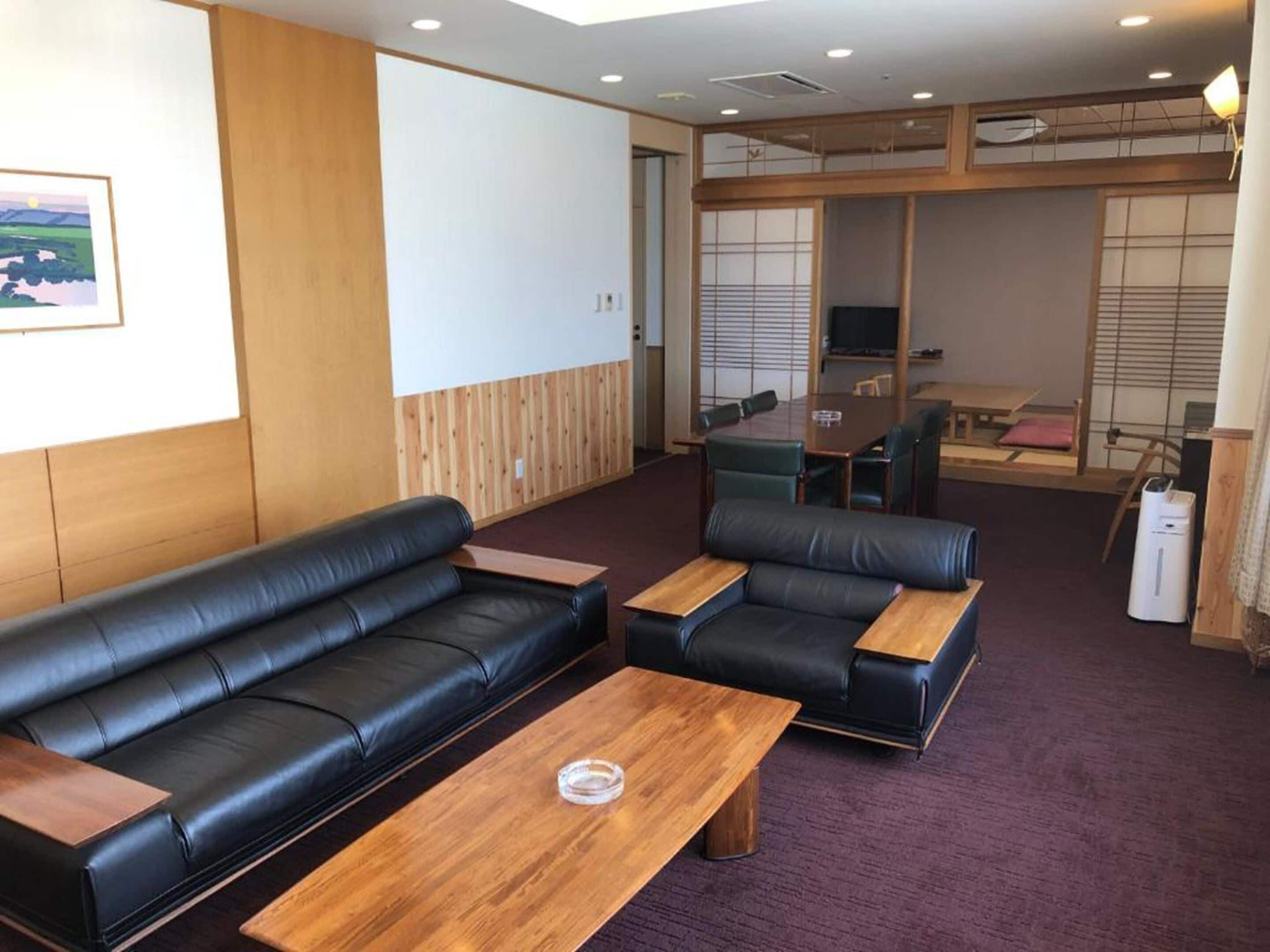 A modern lounge area with leather sofas and a wooden coffee table.