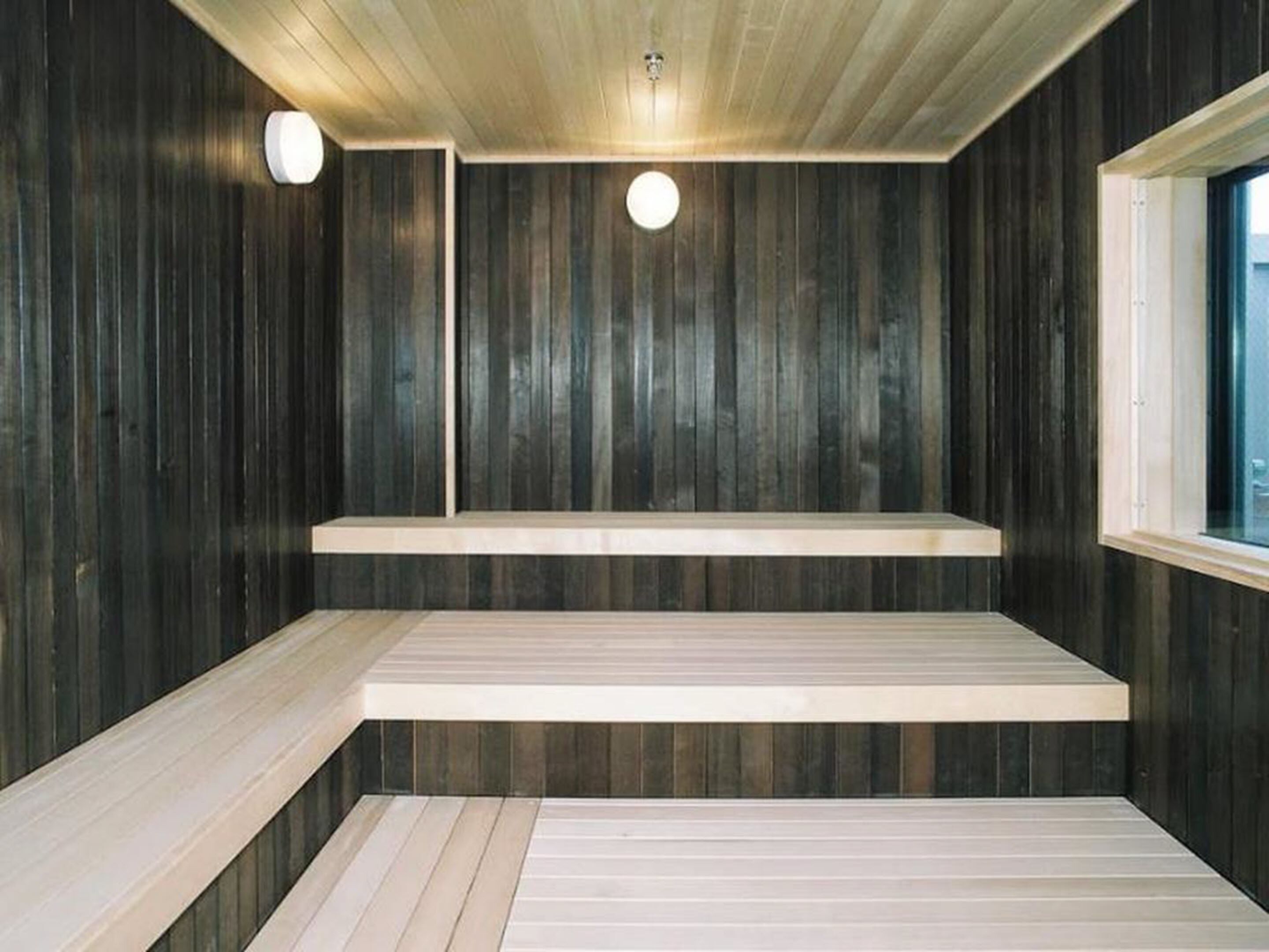 Uma sala de sauna com paredes e bancos de madeira.