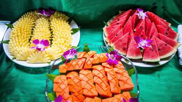 Una mesa con tres platos de fruta dispuesta en un diseño decorativo.