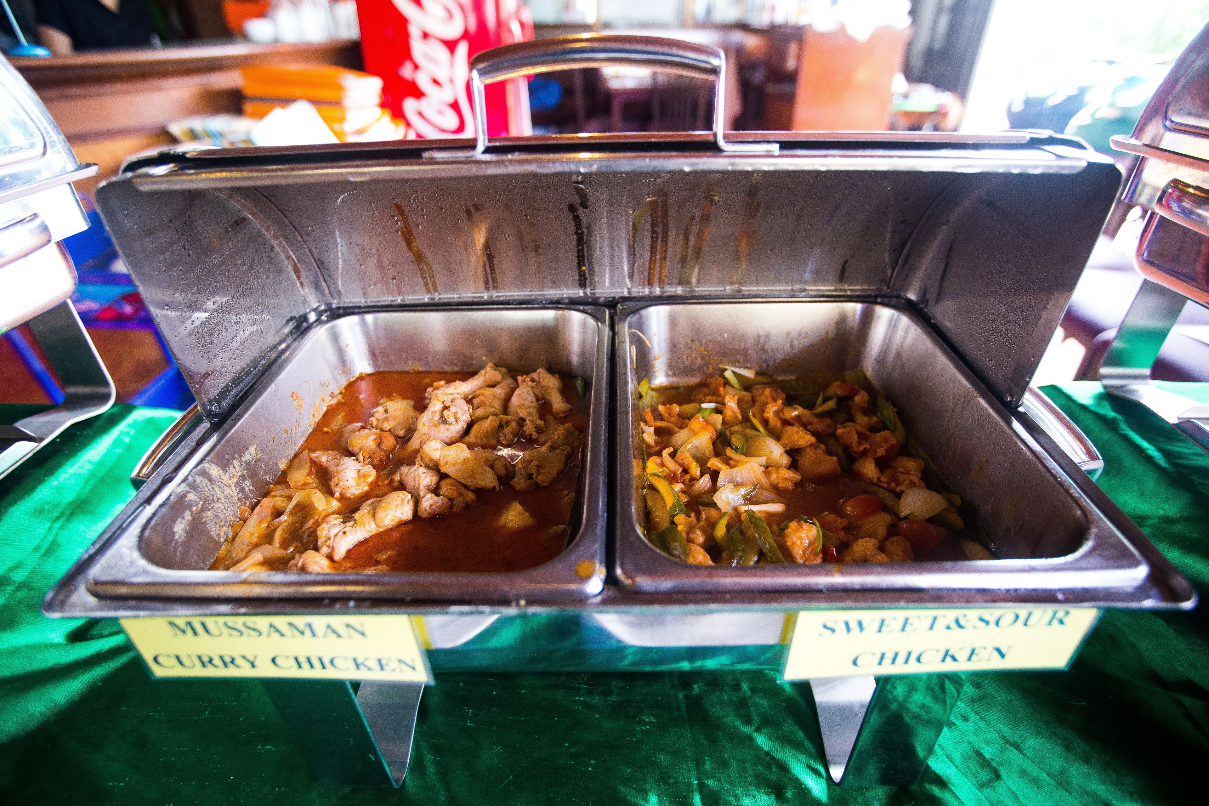 A buffet with two labeled dishes: "Mussaman Curry Chicken" and "Sweet & Sour Chicken".