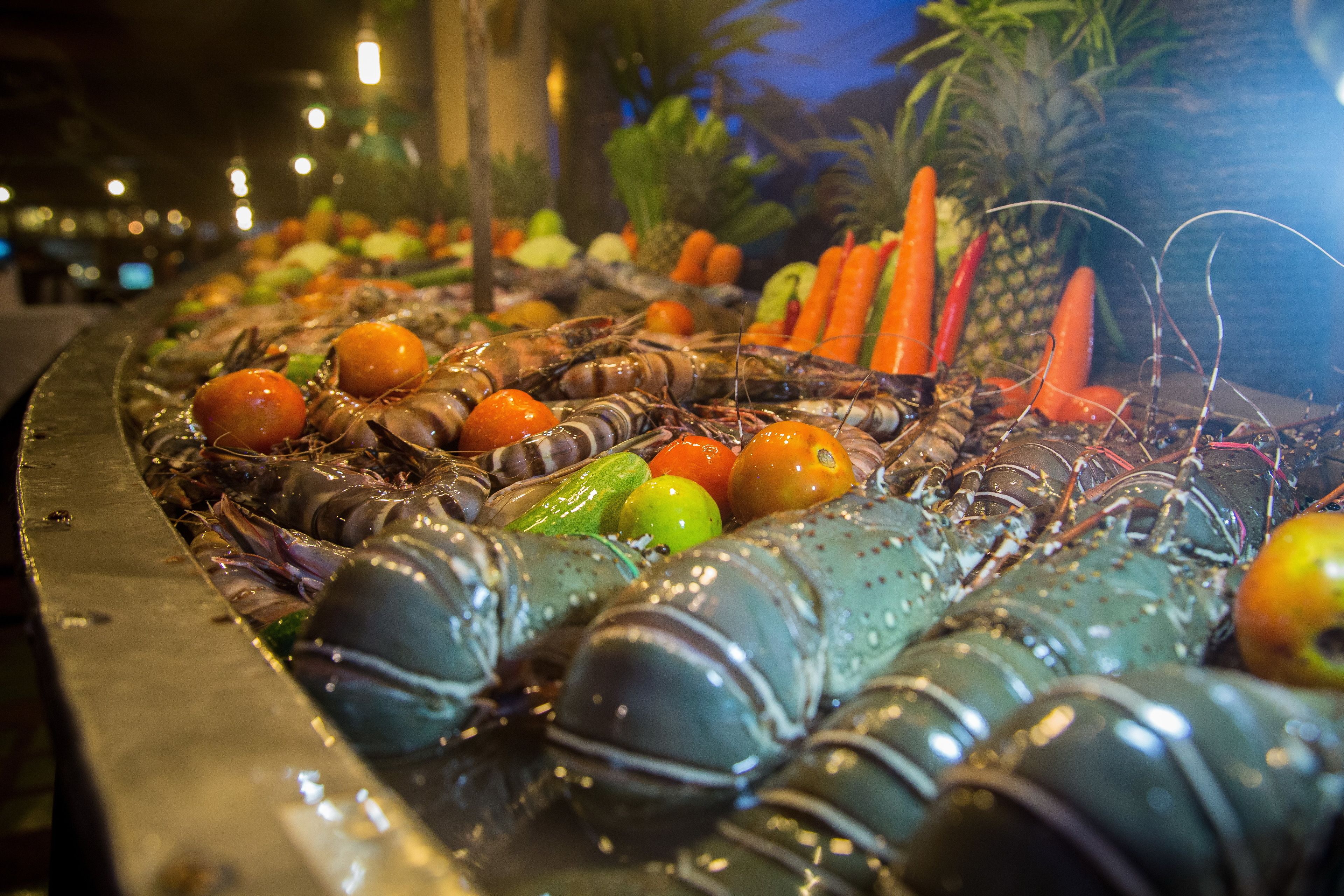 Exhibición de mariscos con langostas y diversas frutas.