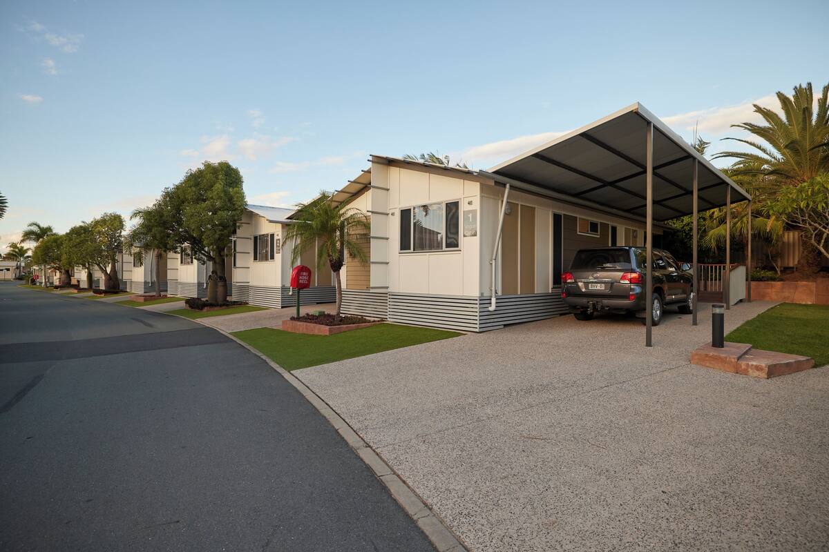 A modern single-story house with a covered garage, a driveway, and a well-maintained lawn.