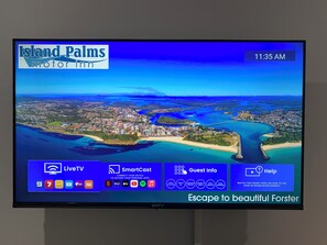 Pantalla de hotel con transmisión en vivo de un pueblo costero, menú SmartCast e información para huéspedes.