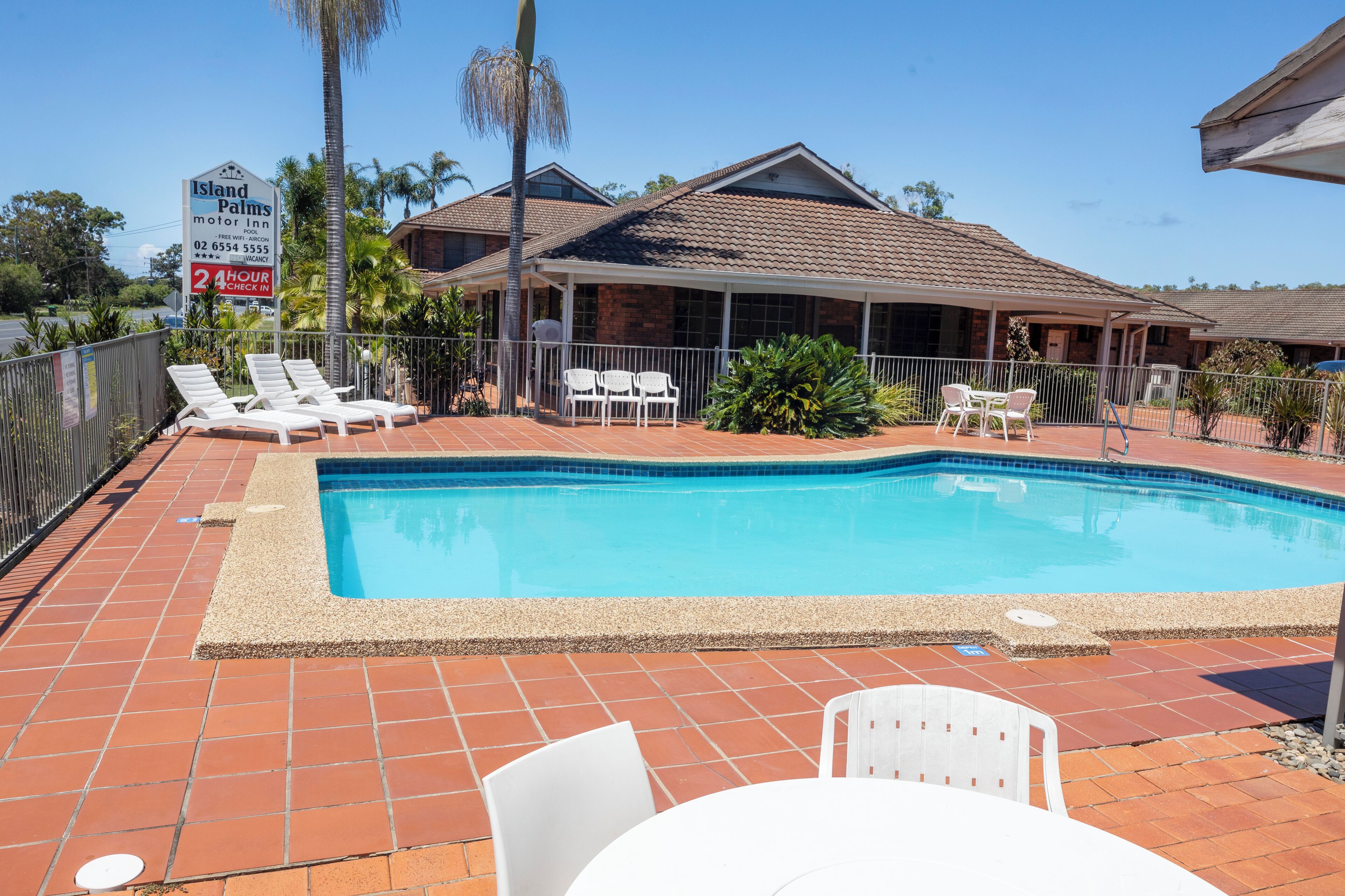 A pool area with lounge chairs and a covered seating area.