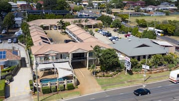 A motel with a swimming pool, spa units, and a parking lot.