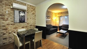 A compact living space with a dining area, a sofa, and a coffee table.