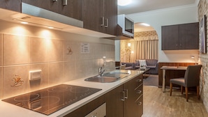 A modern kitchen with a built-in stove, a sink, and dark wooden cabinets.