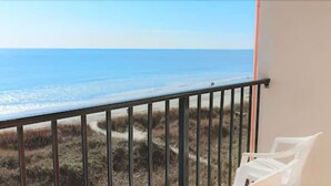 A balcony with a view of the beach and ocean. - Oasis Hotel (North Myrtle Beach)