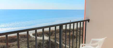 Un balcón con vista a la playa y al océano.