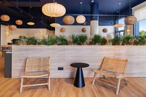 A reception area with wicker chairs, a black table, and hanging spherical light fixtures. - B&B Hotel Albacete  (Albacete)