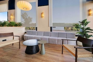 A modern interior with a sofa, chairs, a round table, and a hanging light fixture. - B&B Hotel Albacete  (Albacete)
