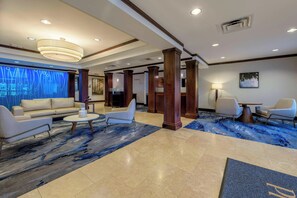 A spacious lobby with a modern design, featuring a large seating area with a sofa and chairs, a coffee table, and a decorative rug. - Fairfield Inn & Suites by Marriott Slippery Rock (Slippery Rock)