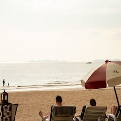 En la playa, sillas reclinables de playa, sombrillas, toallas de playa
