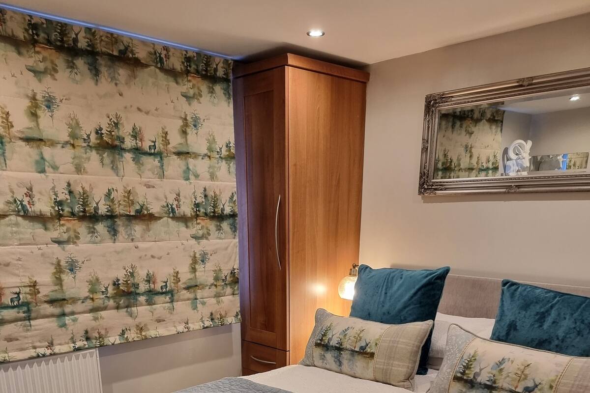 A bedroom with a bed, a wardrobe, and a mirror on the wall.