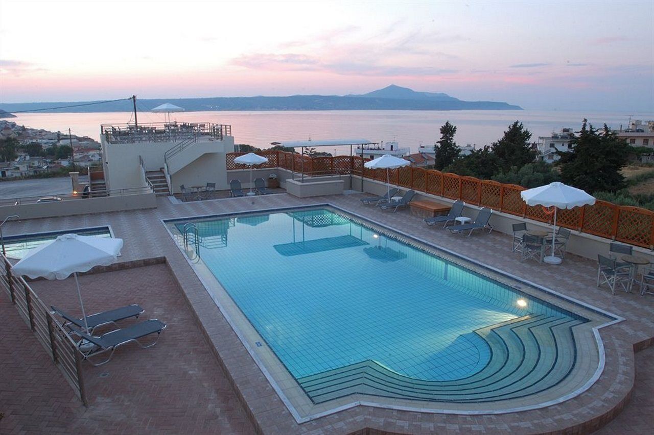 A rooftop swimming pool with a view of the sea and mountains.