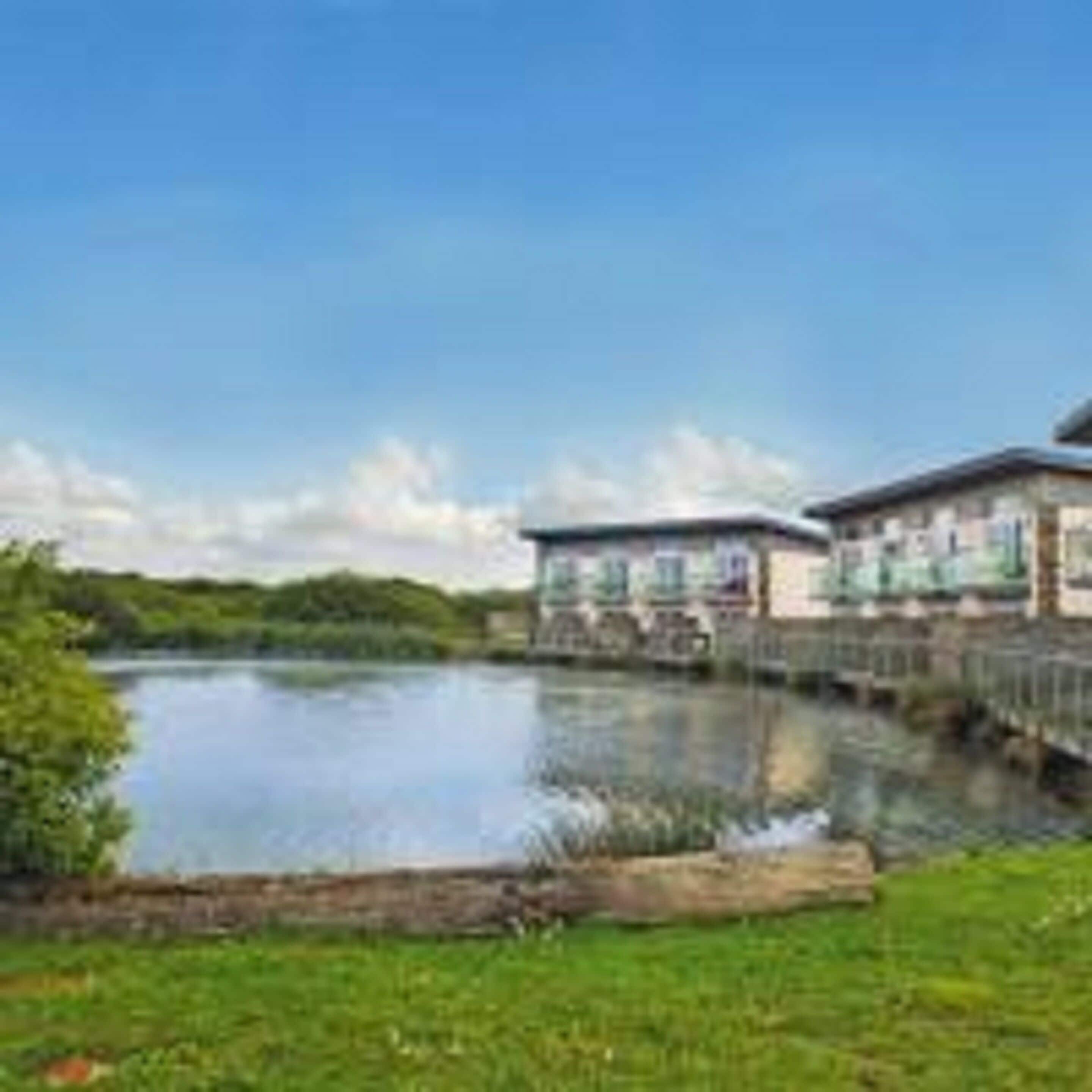 A lakeside hotel with a bridge connecting two buildings.