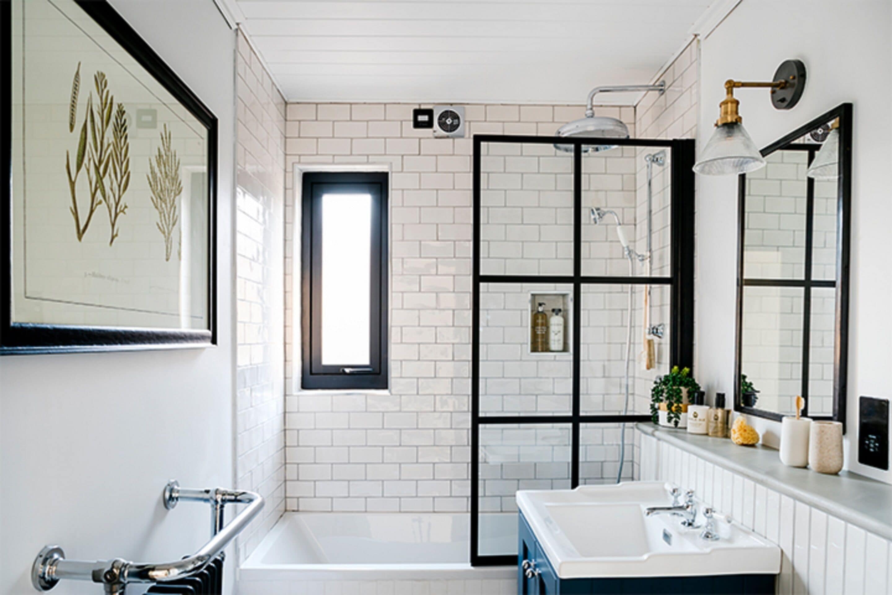 A modern bathroom with a white and black tiled wall, a large window, a bathtub, a sink, and a mirror.