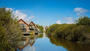A row of houses with a river in the foreground. - Retallack Resort (St. Columb Major)