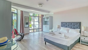 Habitación de hotel moderna con una cama grande, un escritorio con una silla, un armario y vistas al exterior.