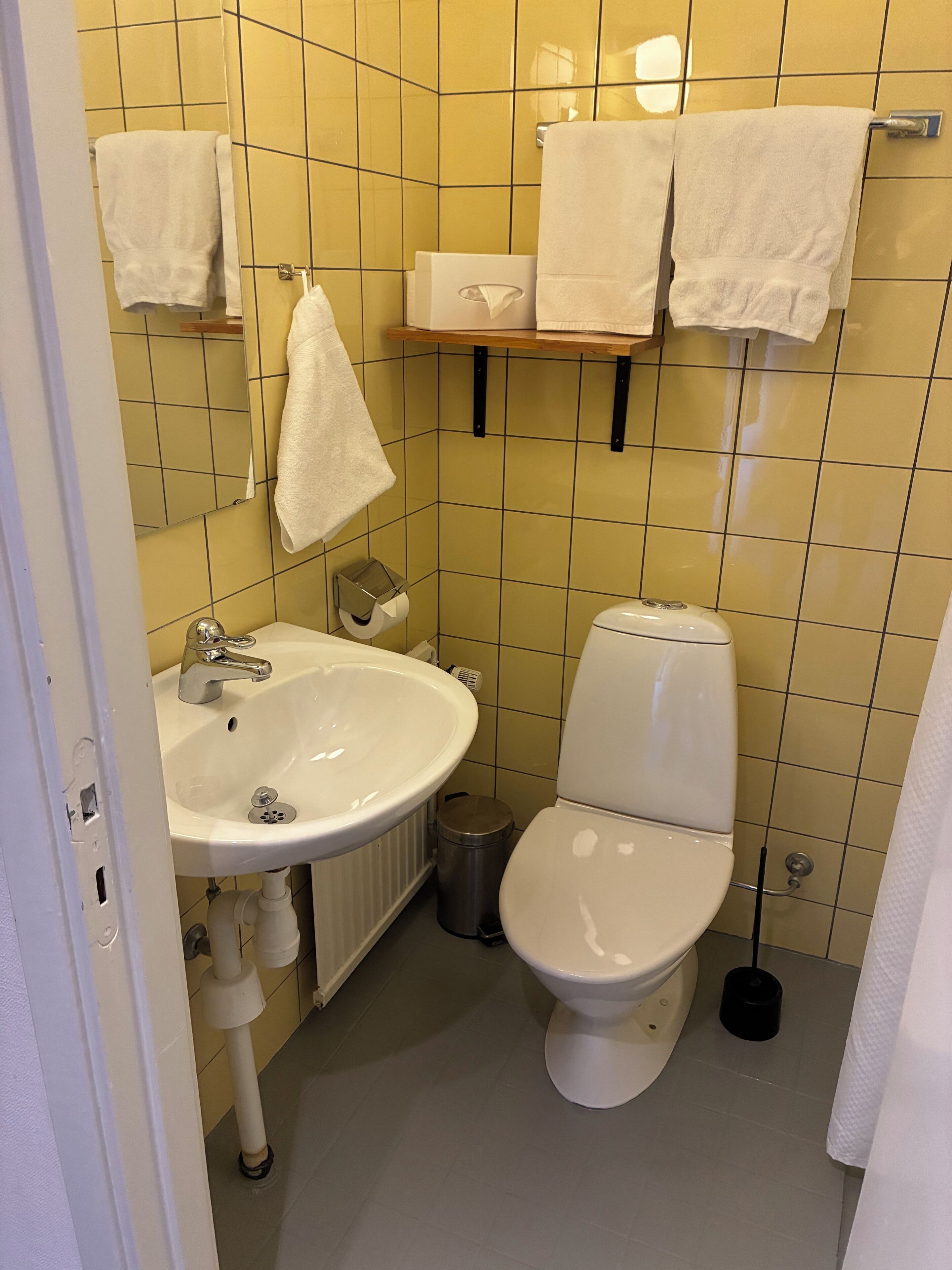 A bathroom with a white sink, toilet, and a towel rack.
