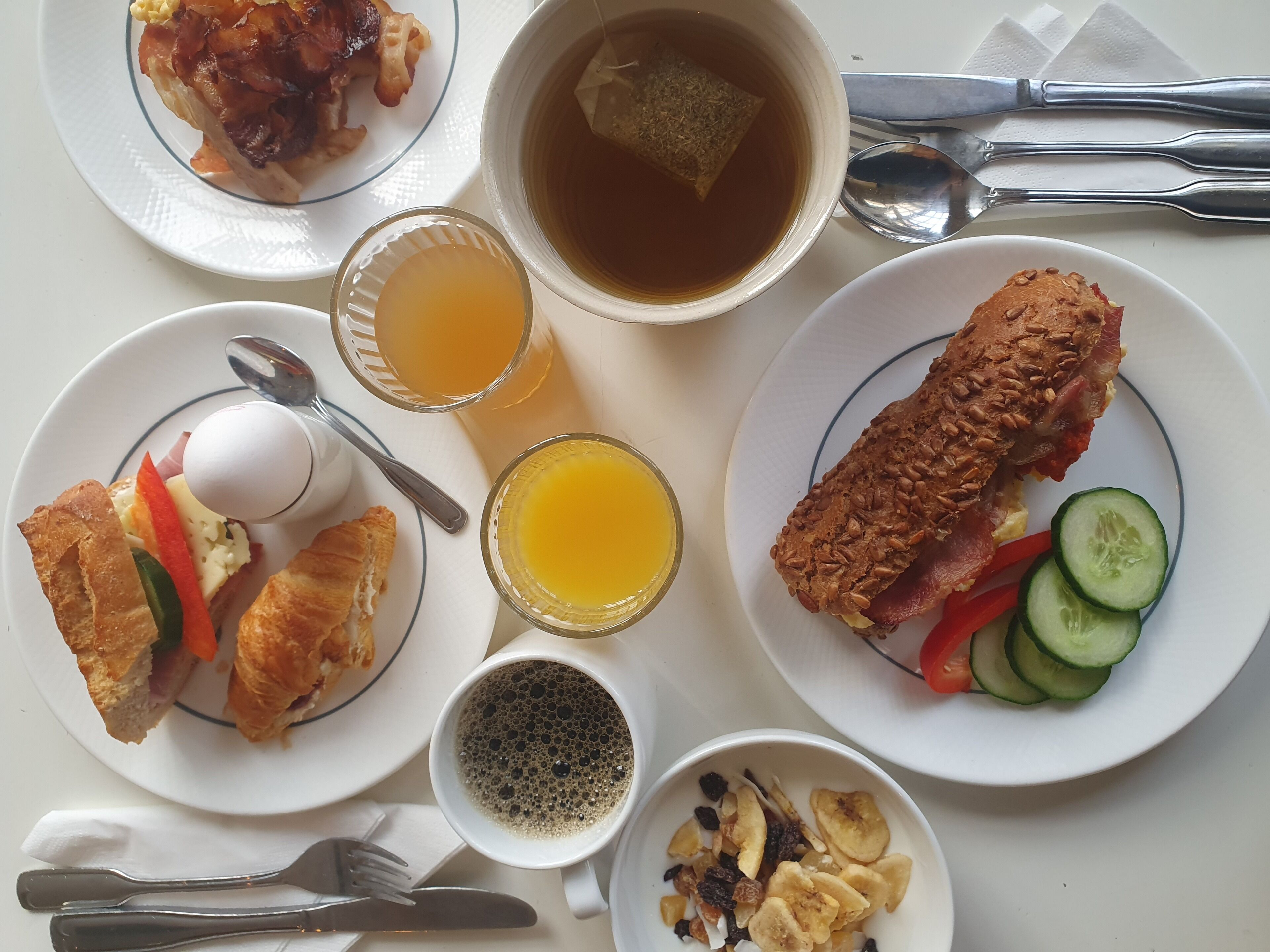 A breakfast setting with various dishes including waffles, eggs, toast, and fruit.