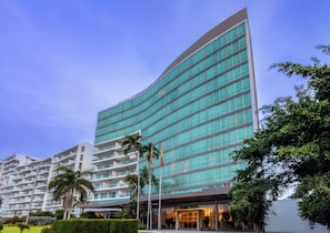 A modern hotel with a curved facade, multiple balconies, and a well-maintained garden area. - AC Hotel by Marriott Cartagena Colombia (Cartagena)