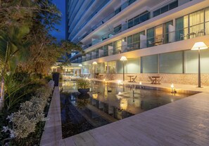 A modern hotel with a pool area, outdoor seating, and a well-lit balcony. - AC Hotel by Marriott Cartagena Colombia (Cartagena)