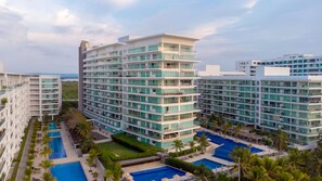 A multi-story hotel with a pool area, including a large central pool and smaller satellite pools. - AC Hotel by Marriott Cartagena Colombia (Cartagena)