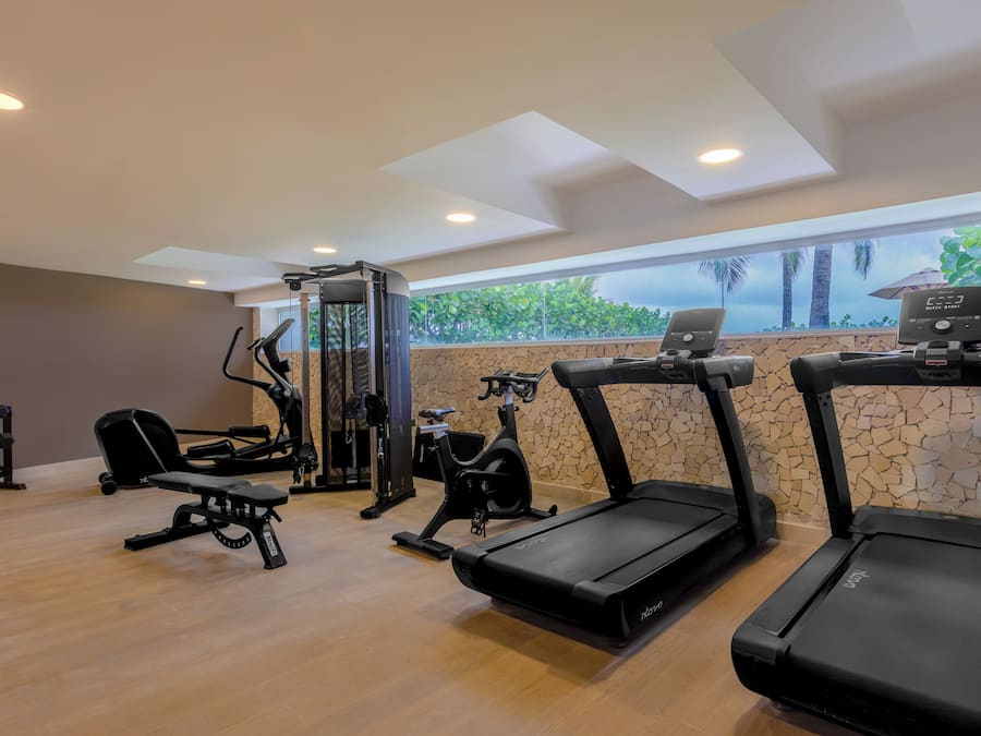 Una palestra con tapis roulant, una panca per pesi e una rack per squat.