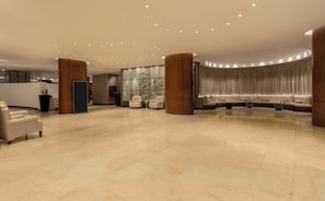 A spacious lobby with a curved seating area, a reception desk, and a large plant. - AC Hotel by Marriott Cartagena Colombia (Cartagena)