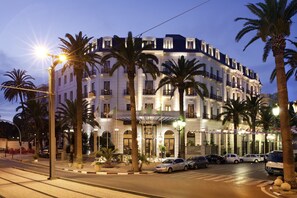 Un hôtel de style architectural européen classique, caractérisé par une façade symétrique, de nombreux balcons et une entrée imposante.